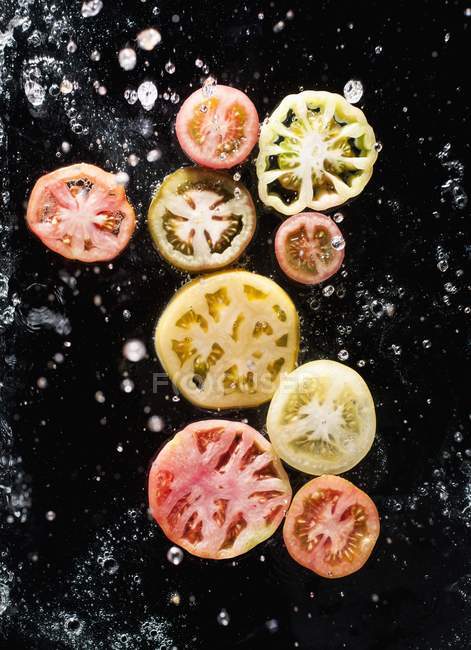 Tomaten in Scheiben geschnitten in Wasser — Stockfoto