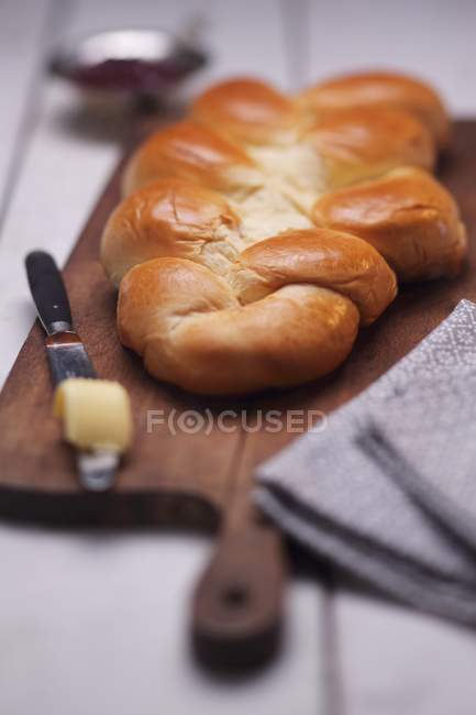 Closeup view of plaited loaf on wooden board — Stock Photo