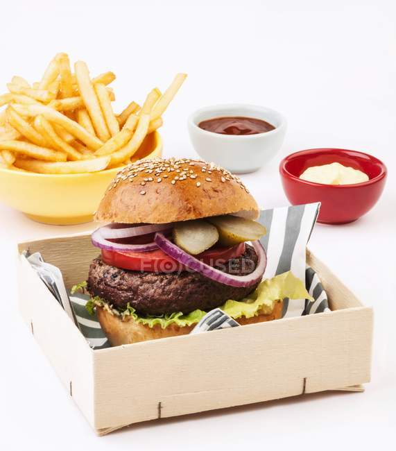 Hamburger served with fries and sauces — Stock Photo