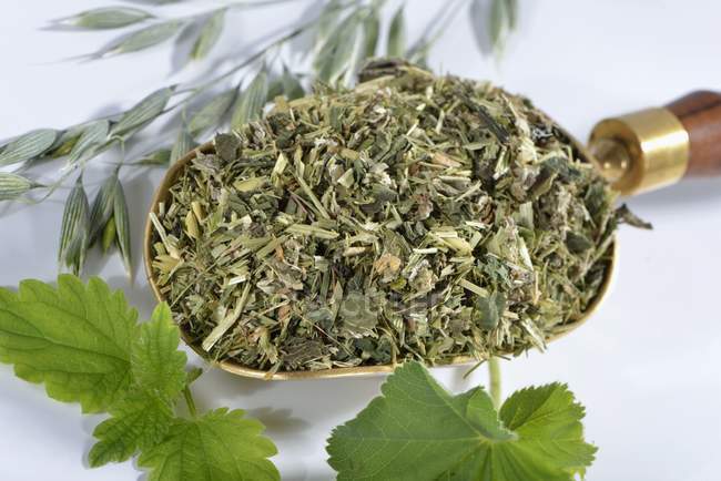 Closeup view of a mixture of herbs on a brass scoop — Stock Photo