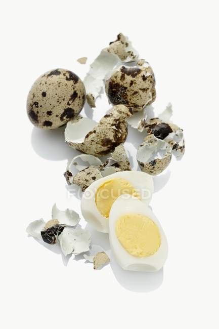 Vista de cerca de huevos de codorniz duros y cáscaras de huevo - foto de stock