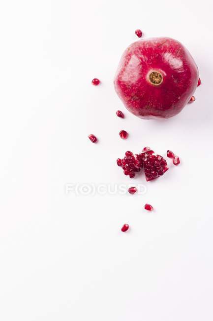 Whole pomegranate and seeds — Stock Photo