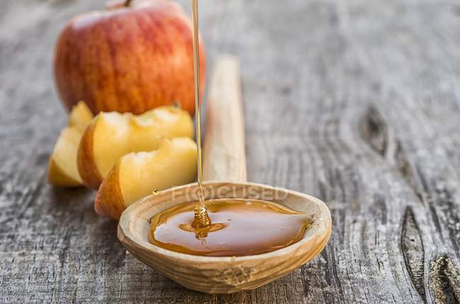 Miel tombant sur une cuillère en bois — Photo de stock