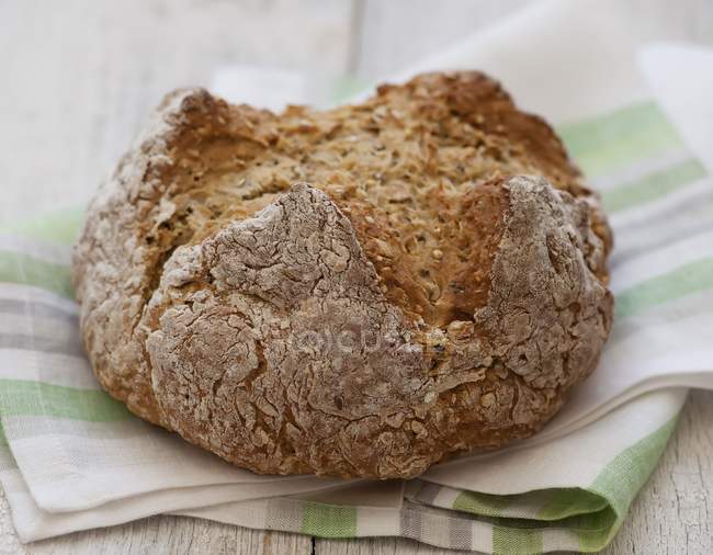 Rustikales Brot auf gestreiftem Tuch — Stockfoto