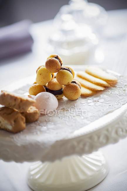 Closeup view of Dolci assortiti baked goods on doily and stand — Stock Photo
