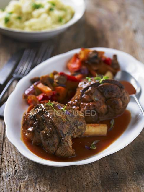 Braised lamb shanks with peppers — Stock Photo