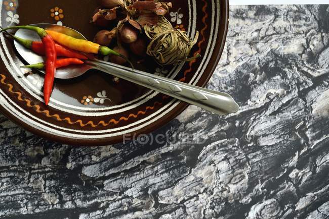 Peperoncini e aglio in ciotola con cucchiaio — Foto stock