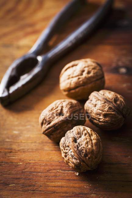 Nueces y un cascanueces en madera - foto de stock