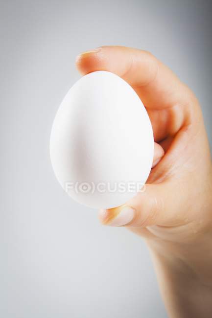 Mano femminile che tiene uovo — Foto stock