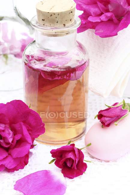 Vista close-up de água de rosas caseira com rosas e sabão — Fotografia de Stock