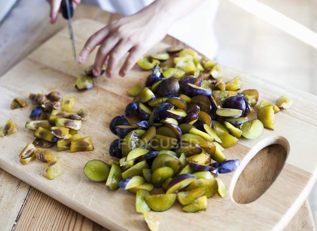 Woman slicing plums — Stock Photo