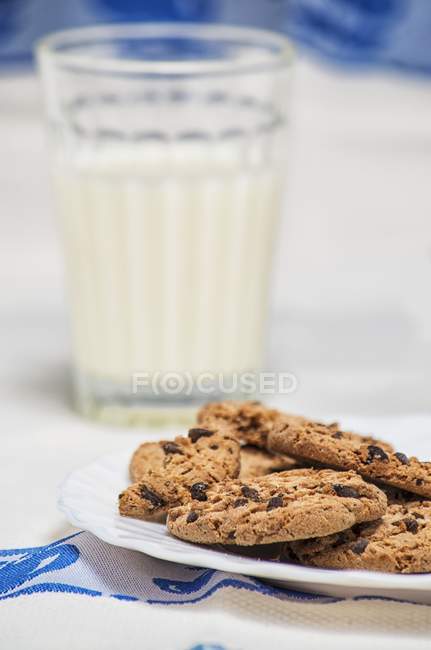 Biscuits aux pépites de chocolat avec verre de lait — Photo de stock
