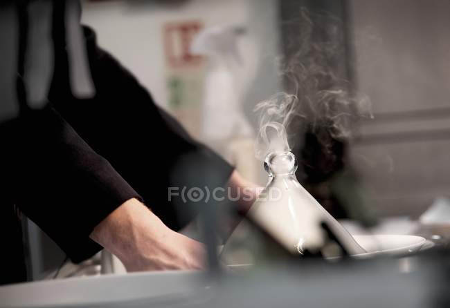 Abgeschnittene Ansicht von Händen, die Schüssel mit rauchender Cloche halten — Stockfoto