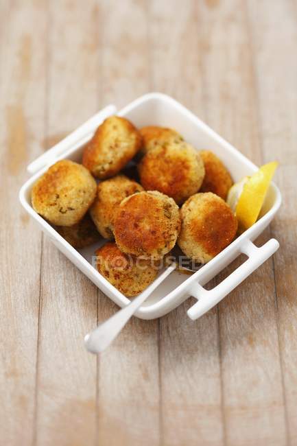 Pasteles de pescado con guisantes en tazón - foto de stock