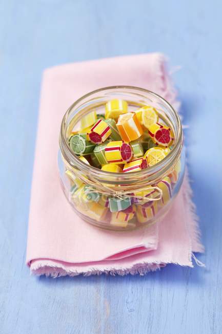 Vista de cerca de dulces de frutas de colores en frasco de vidrio - foto de stock