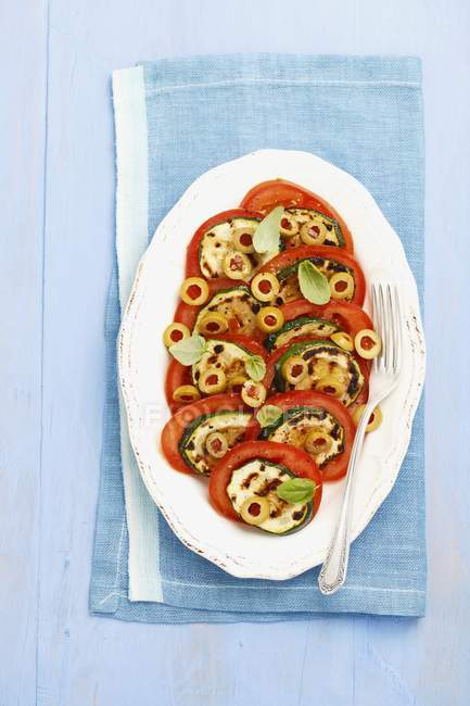 Tomato salad with olives and grilled courgette — Stock Photo