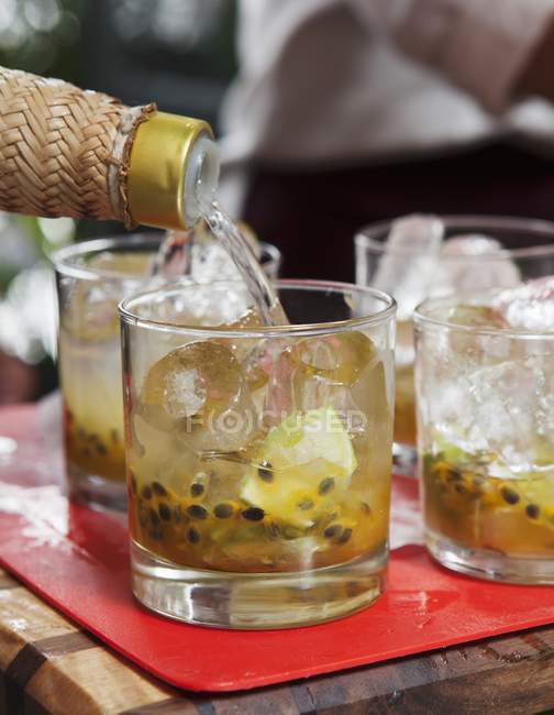 Closeup view of pouring drink to iced fruity cocktail — Stock Photo