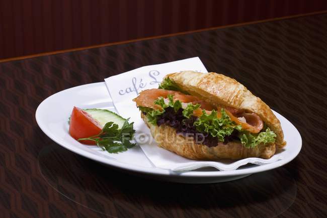 Croissant with salmon and salad — Stock Photo