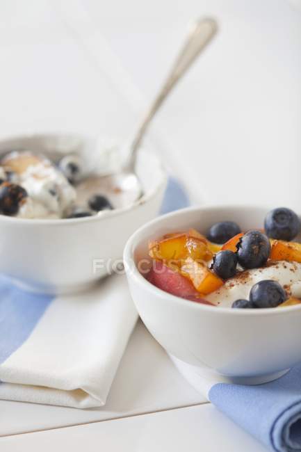 Йогурт з чорницею, муслі та персиками — стокове фото