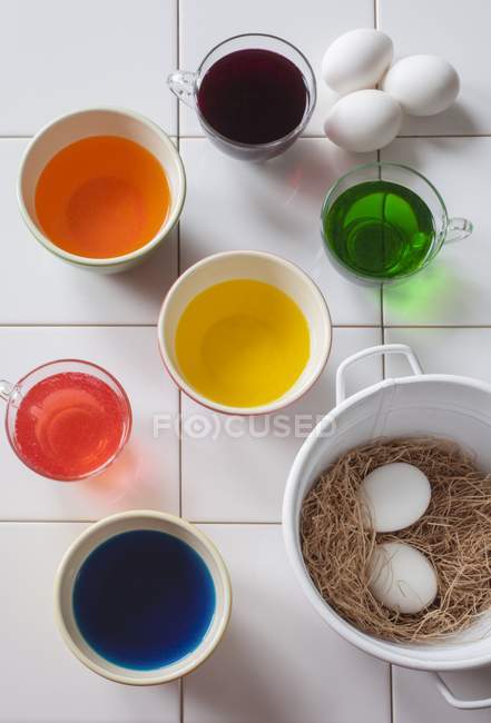 Vista superior de líquidos coloridos para colorear huevos de Pascua - foto de stock