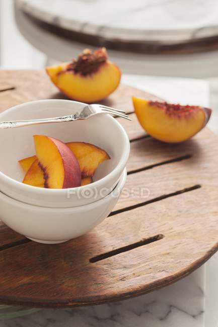 Миска зі свіжих шматочків персика — стокове фото