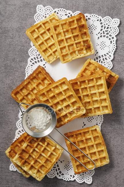 Waffles and a sieve of icing sugar — Stock Photo