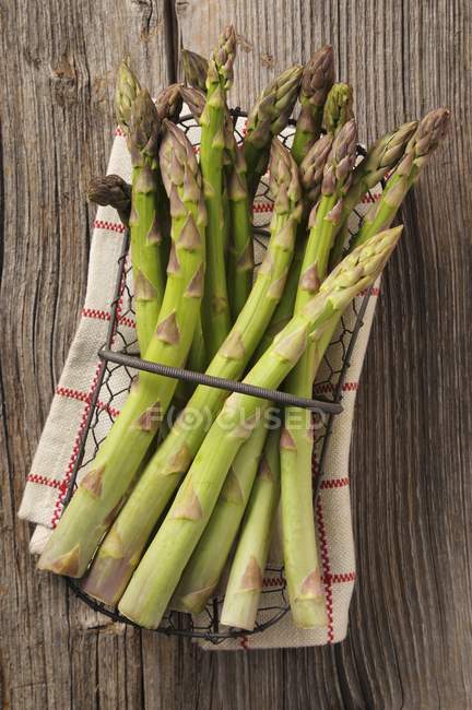 Green asparagus in wire basket — Stock Photo