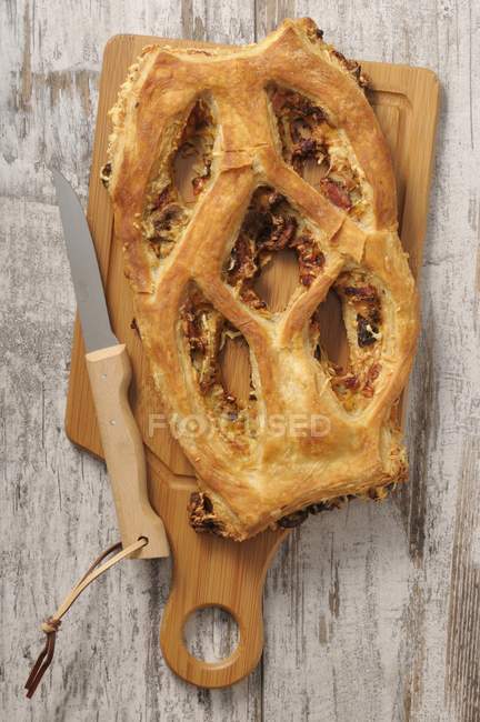 Top view of Fougasse with a knife on a chopping board — Stock Photo
