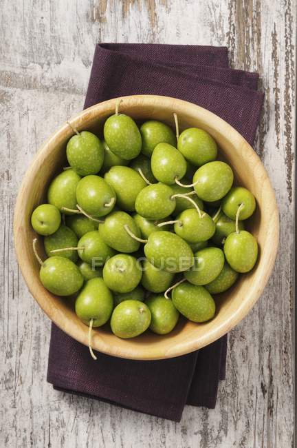 Azeitonas verdes frescas em tigela de madeira — Fotografia de Stock