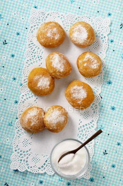 Sugared doughnuts on tablecloth — Stock Photo