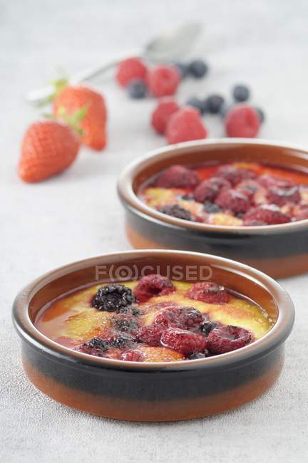 Closeup view of Gratin Dauphinois in bowls with berries — Stock Photo