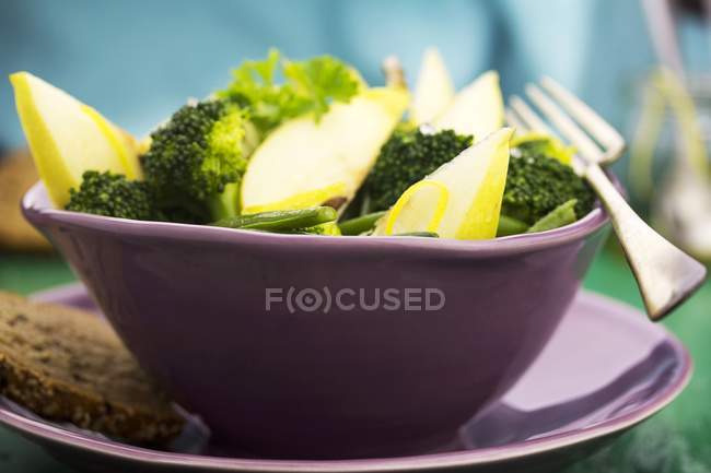 Салат з брокколі та груші у фіолетовій мисці — стокове фото
