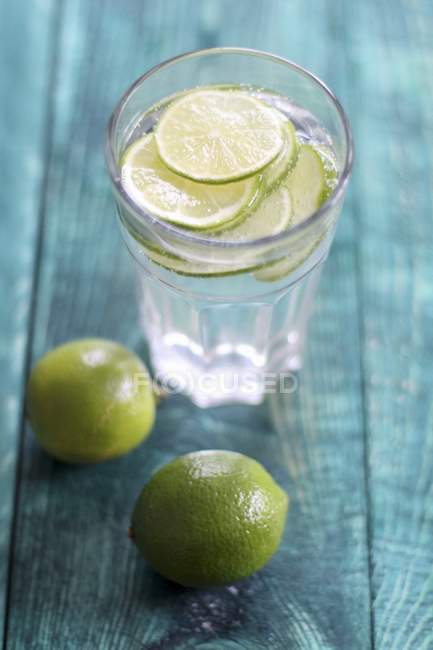 Verre d'eau avec des citrons verts frais — Photo de stock