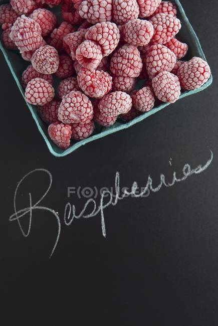 Frozen raspberries with text — Stock Photo