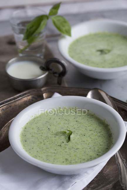 Повышенный вид на базилик и испорченный молочный суп в мисках — стоковое фото