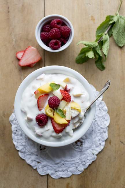 Quark de frutas con menta en tazón blanco sobre servilleta - foto de stock