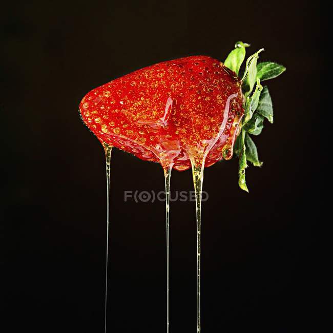 Erdbeere tropft mit Honig — Stockfoto