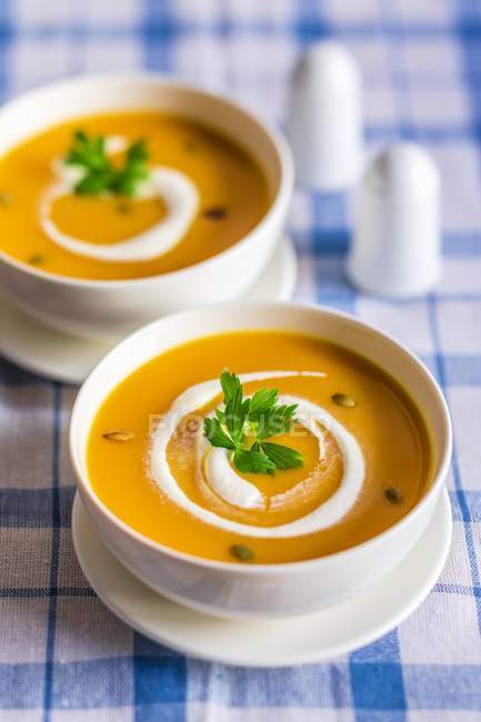 Сливки из тыквенного супа со сметаной в маленьких мисках — стоковое фото