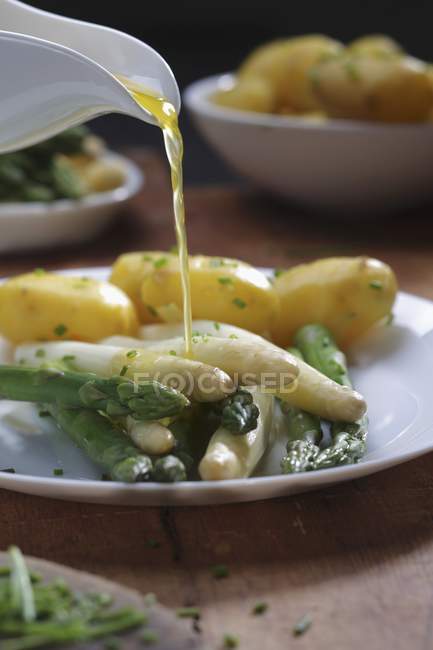 Verter manteiga derretida sobre espargos — Fotografia de Stock