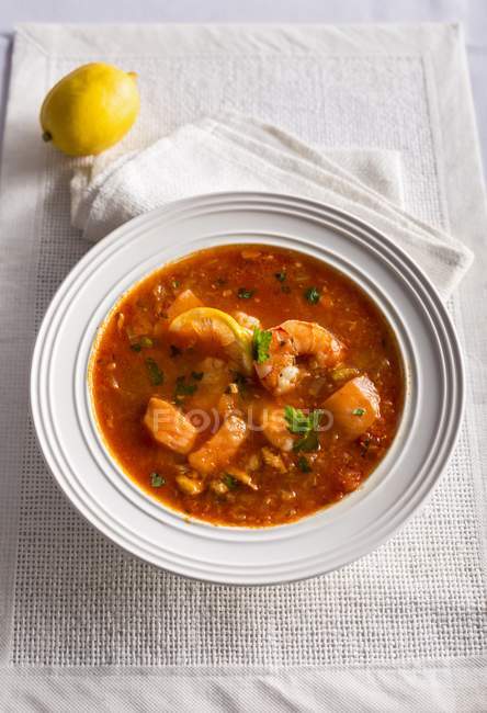 Zuppa di pesce allá siciliana - sopa de pescado en plato blanco - foto de stock