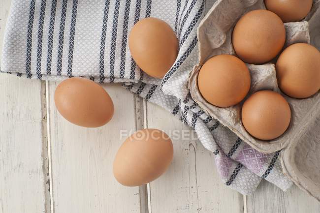 Brown eggs in egg box with fabric — Stock Photo