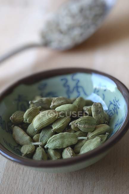 Зеленый кардамон в керамической чаше — стоковое фото