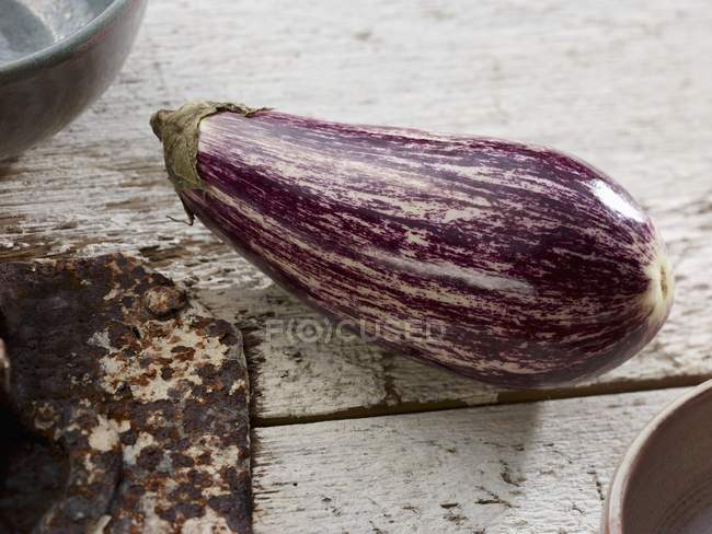 Une aubergine rayée sur de vieux planches blanches — Photo de stock