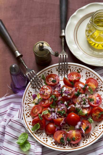 Tomates com cebola vermelha e salada de manjericão — Fotografia de Stock