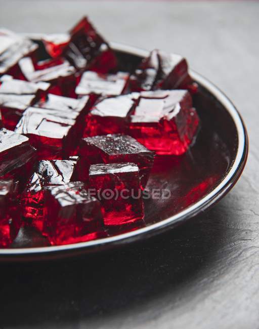 Cubos de gelatina roja en el plato - foto de stock