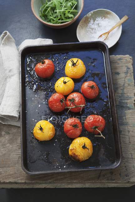 Tomates vermelhos e amarelos assados em uma bandeja de cozedura — Fotografia de Stock
