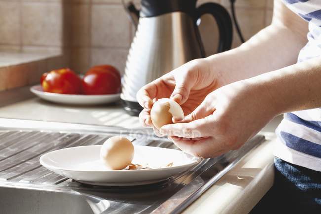 Abgeschnittene Ansicht einer Frau, die hartgekochte Eier schält — Stockfoto