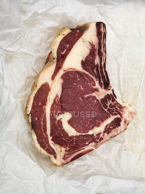Steak de boeuf cru sur papier — Photo de stock