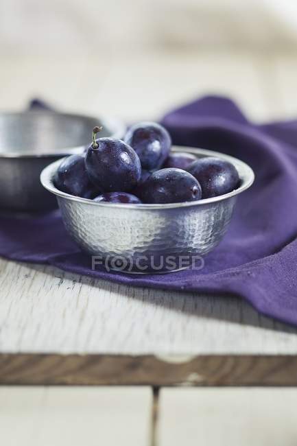 Plums in metal bowl — Stock Photo