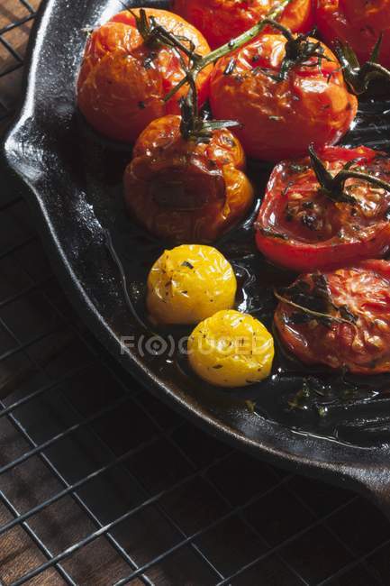 Tomates vermelhos e amarelos assados em uma panela de ferro fundido — Fotografia de Stock